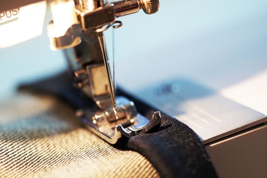 close up of sewing machine working in tailoring jeans