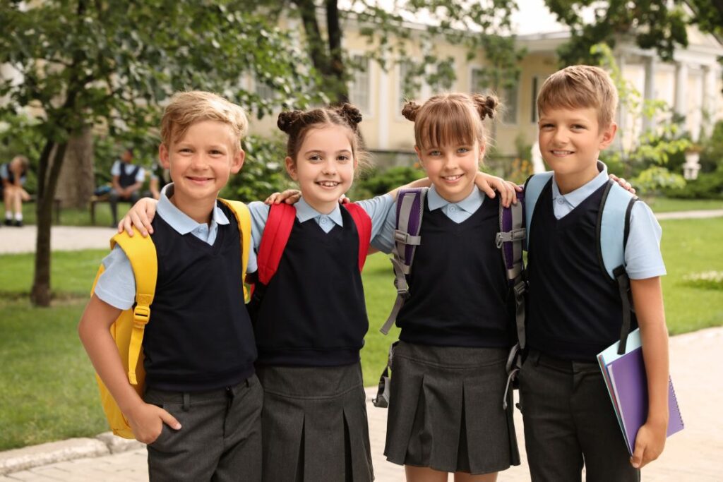 happy kids in school uniforms after getting clothing alterations