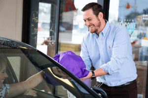Keans owner bringing clean laundry to car at the dry cleaning drive through