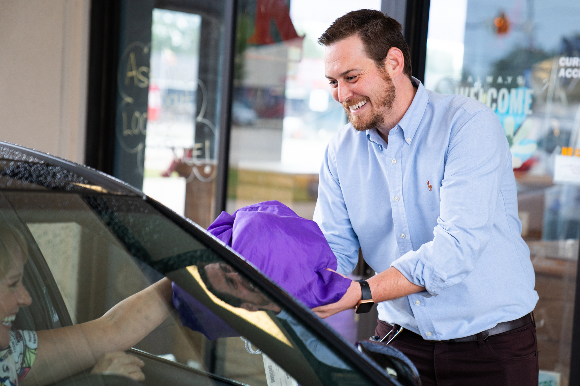 Keans owner bringing clean laundry to car at the dry cleaning drive through