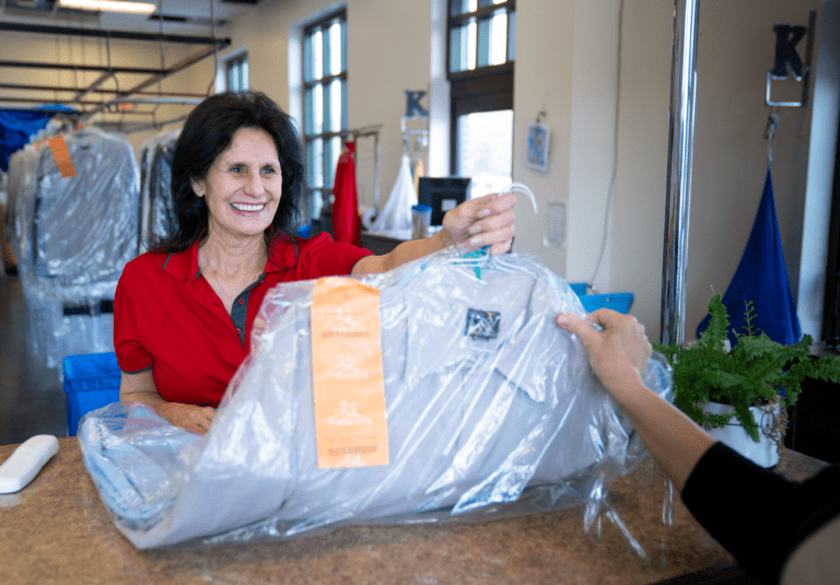 keans employee hands dry cleaned mens dress shirts to customer in baton rouge towne center location