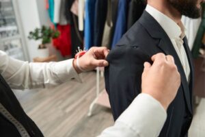 tailor working on suit alteration and adjusting shoulders