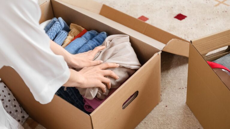 woman storing clothes after summer in a box
