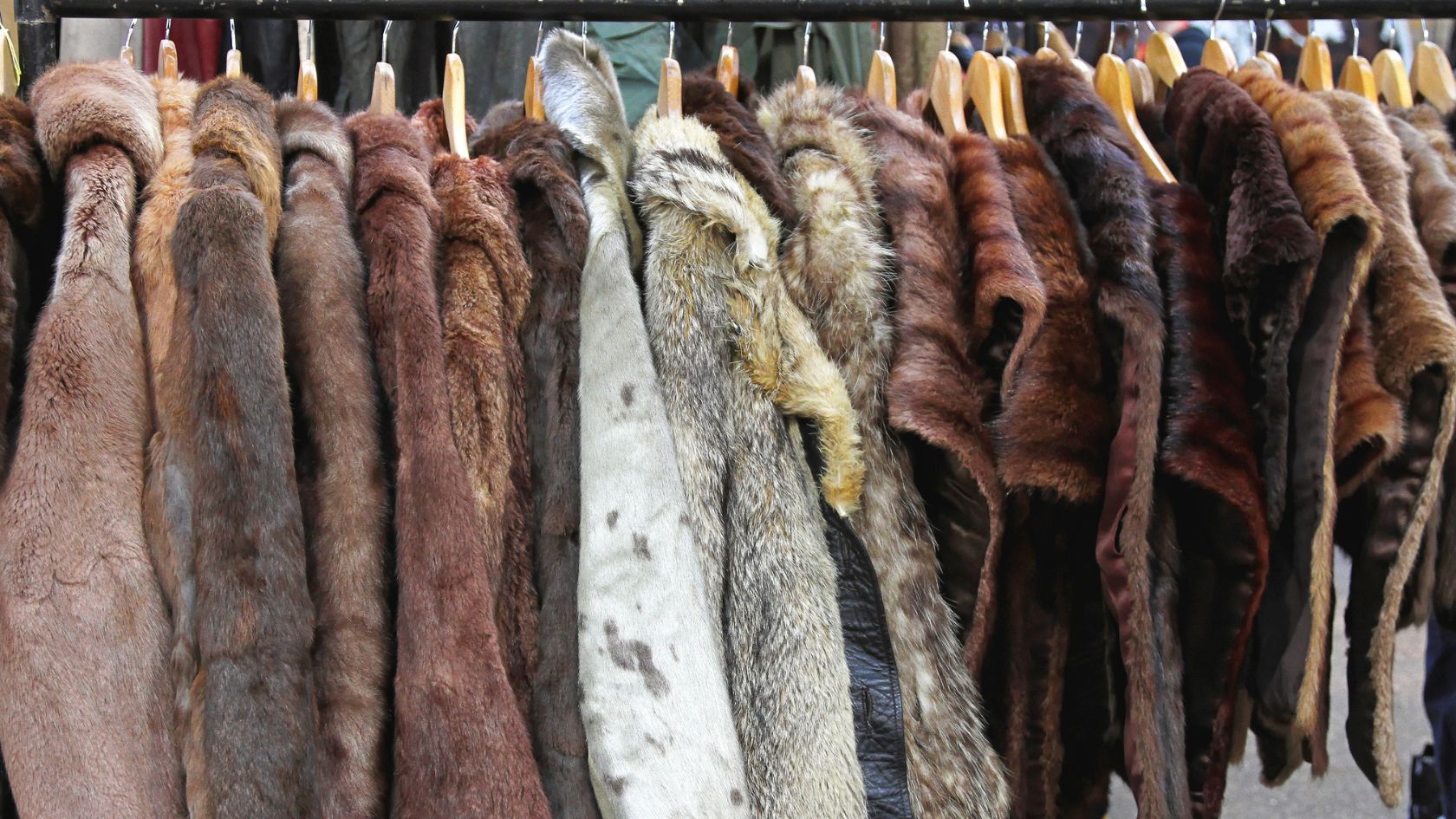 a rack of vintage fur coats on hangers